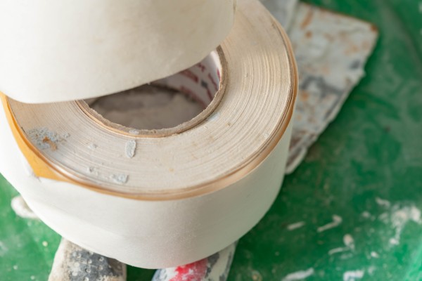 masking tape on dirty tools on a dark green table in a workshop